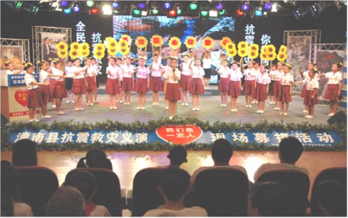 图为实验二小学生在抗震救灾义演现场，表演童心手语《感恩的心》。